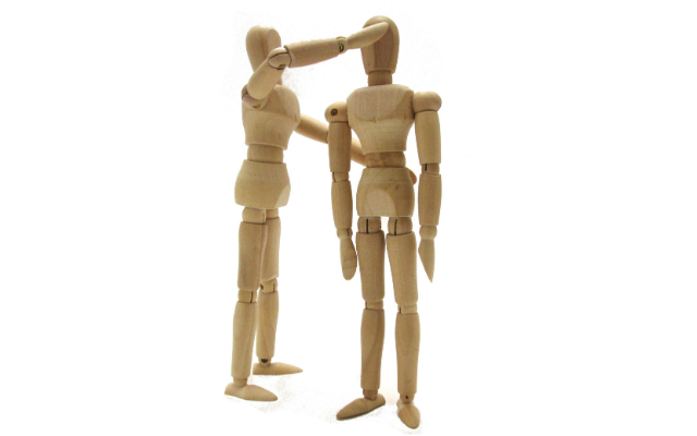 Two wooden anatomical figures correcting posture